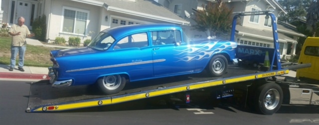 Photo of a Chevy Bel Air loaded being hauled by a tow truck.